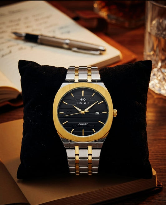 Two-tone watch on a black cushion with a blurred background